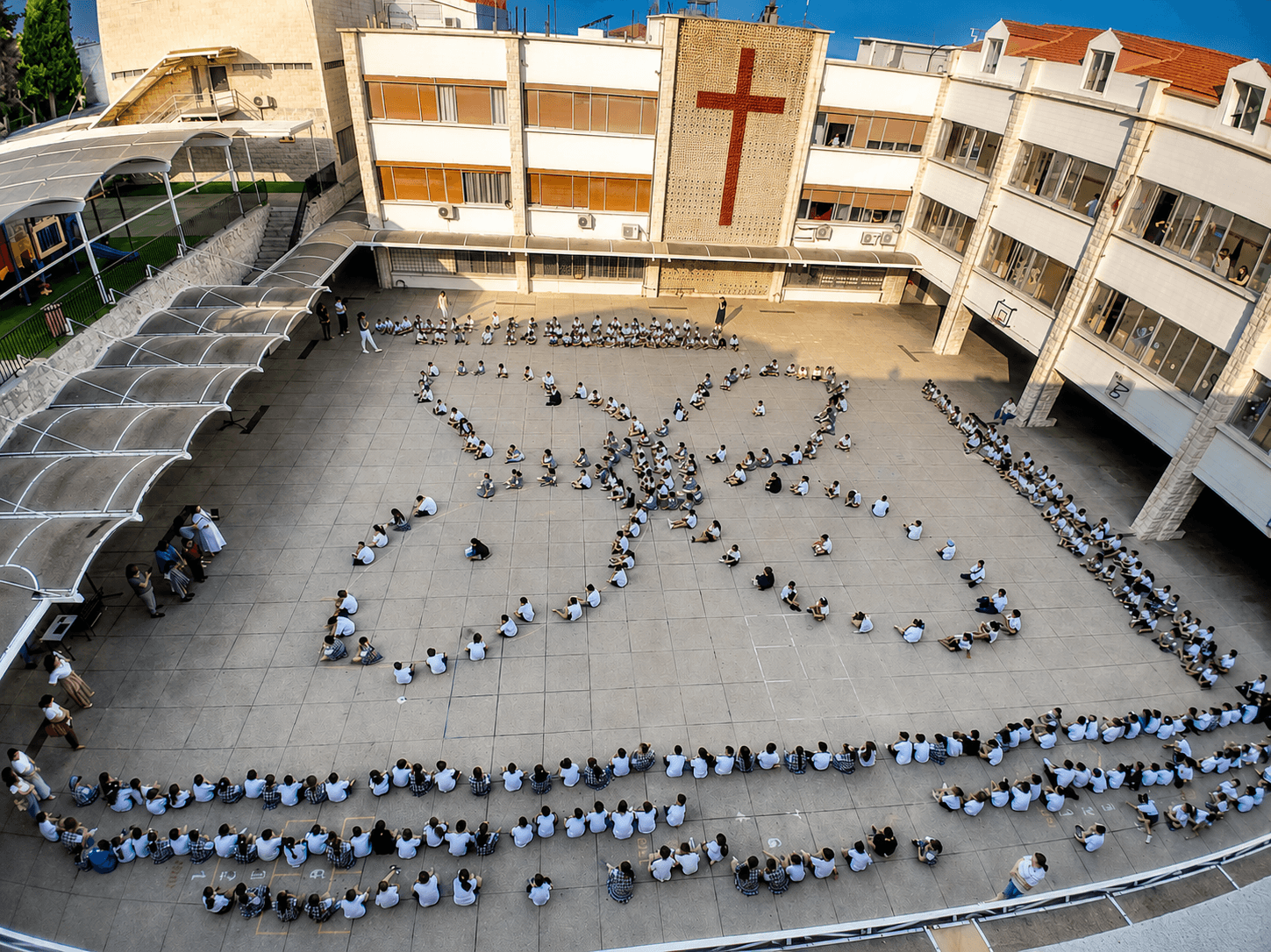 Students gathered in the school courtyard forming a unity pattern